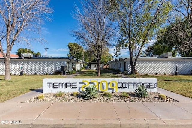 community / neighborhood sign featuring a yard