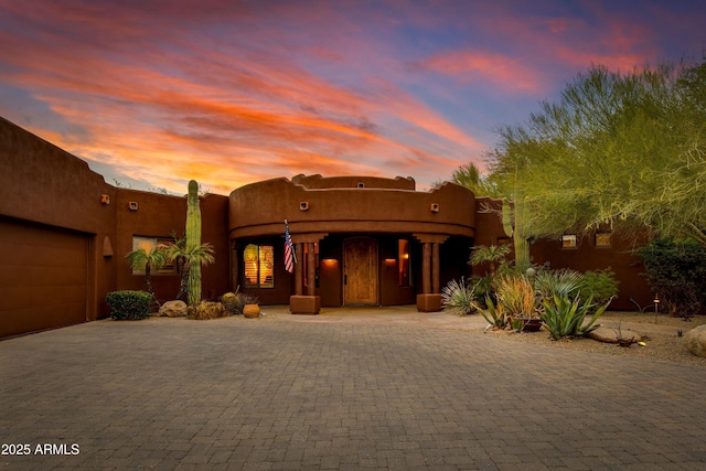 pueblo revival-style home featuring a garage