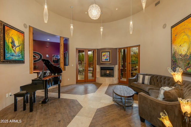 interior space with a high end fireplace, a high ceiling, french doors, and a healthy amount of sunlight