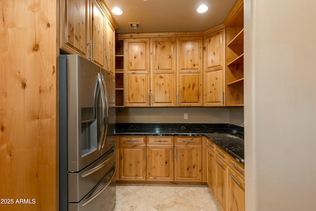 kitchen featuring light tile patterned flooring, stainless steel fridge with ice dispenser, and dark stone countertops