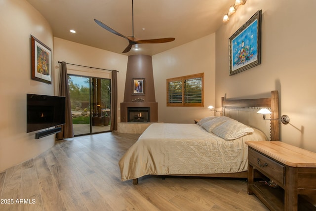 bedroom with access to exterior, ceiling fan, and wood-type flooring