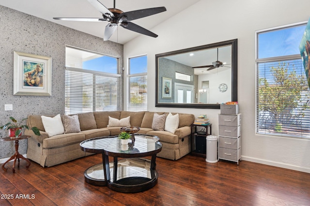 living area featuring a wealth of natural light, dark wood-style flooring, lofted ceiling, and baseboards