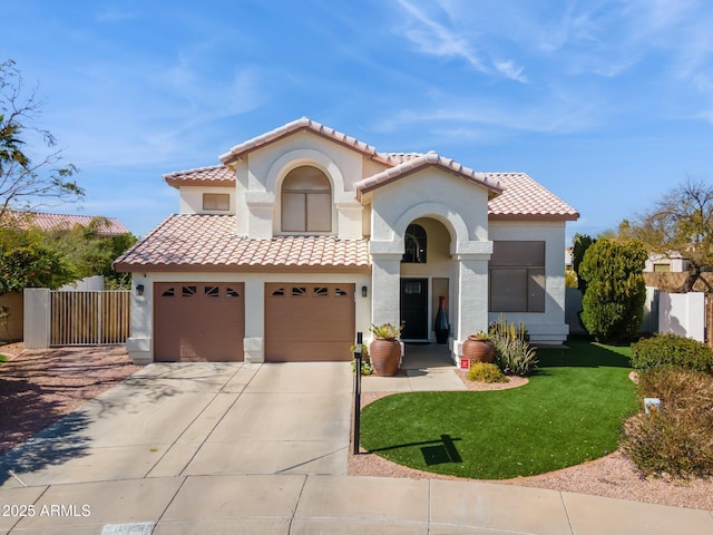 mediterranean / spanish-style home with a garage, concrete driveway, fence, and stucco siding