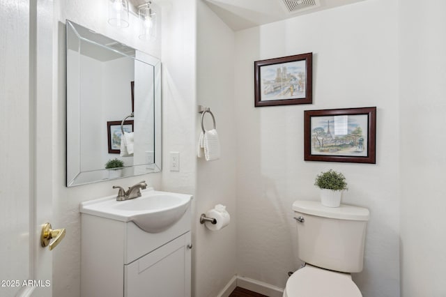 bathroom with toilet, baseboards, visible vents, and vanity