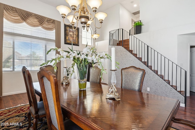 dining area featuring an inviting chandelier, stairs, and wood finished floors