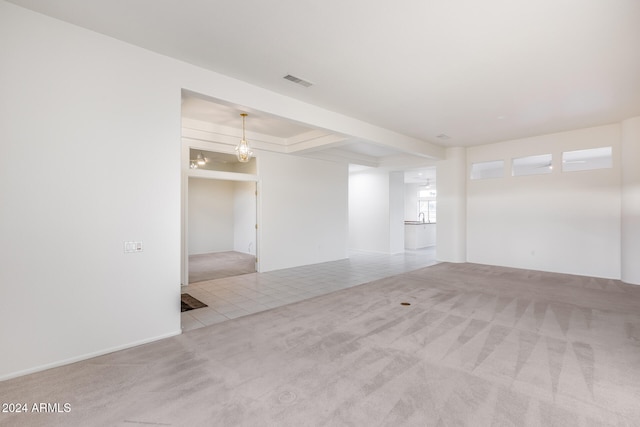 carpeted spare room with a raised ceiling