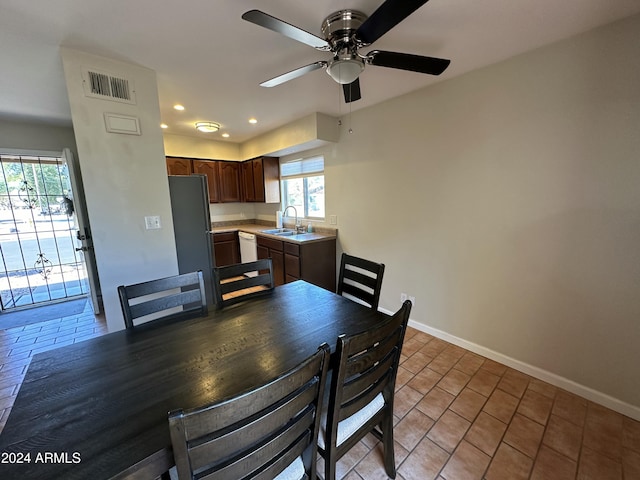 dining space with tile patterned floors, ceiling fan, and sink