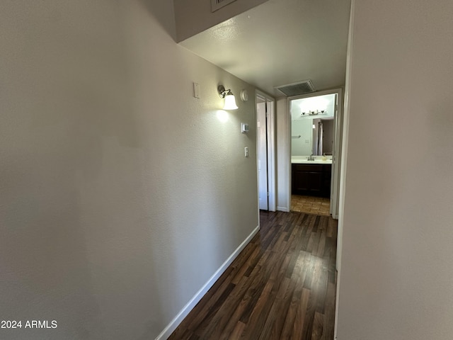 hall with sink and dark wood-type flooring