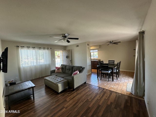 living room with ceiling fan and dark wood-type flooring