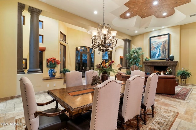 dining space featuring a notable chandelier and decorative columns