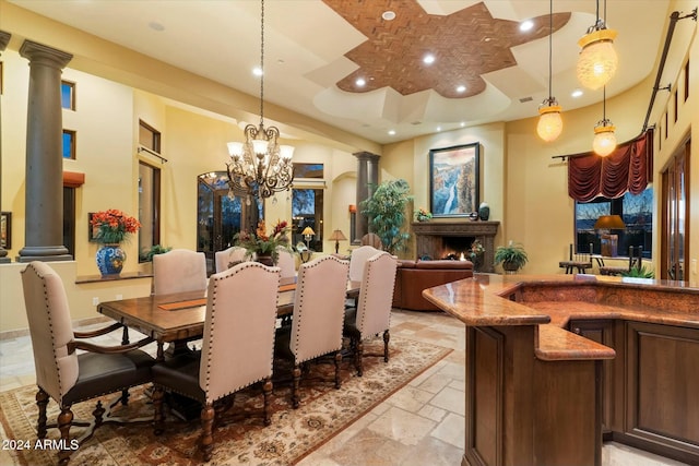 dining space featuring decorative columns and an inviting chandelier