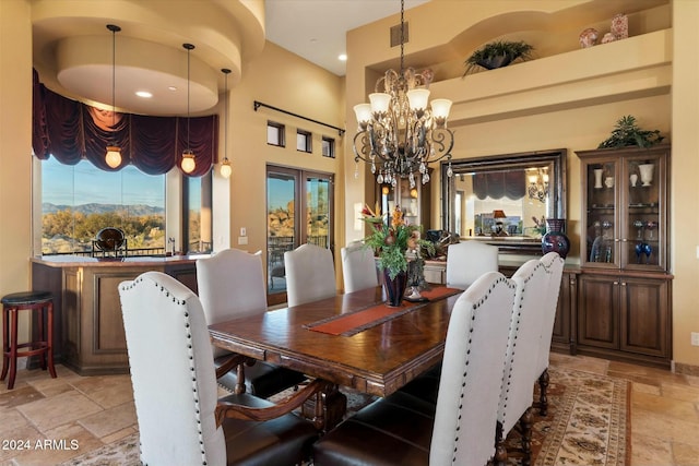 dining space featuring french doors, a high ceiling, and a chandelier