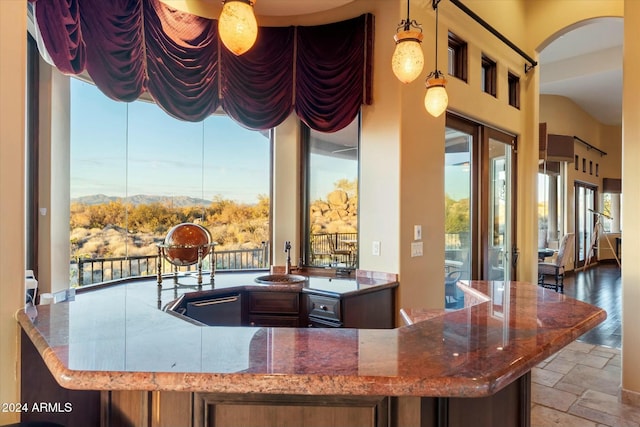 interior space featuring pendant lighting, stone countertops, and sink