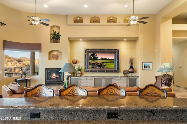 living room with built in shelves and ceiling fan