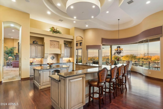 kitchen with a breakfast bar, decorative light fixtures, a large island, a notable chandelier, and kitchen peninsula