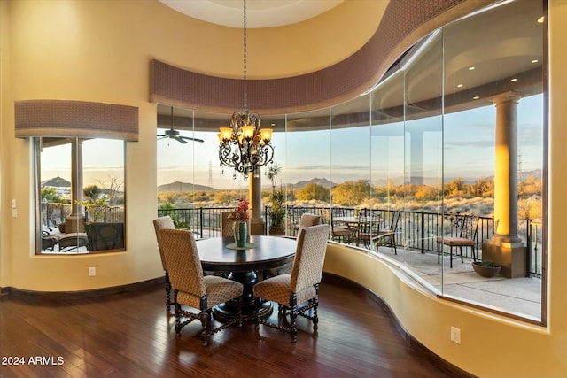 dining space featuring a wealth of natural light, a mountain view, wood-type flooring, and ceiling fan with notable chandelier