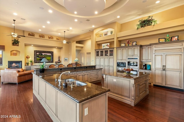 kitchen featuring a spacious island, sink, pendant lighting, built in features, and dark hardwood / wood-style floors