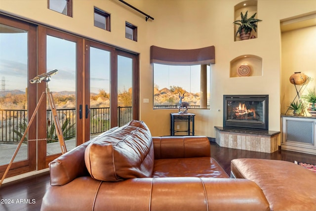 living room with dark hardwood / wood-style flooring, a high ceiling, and french doors