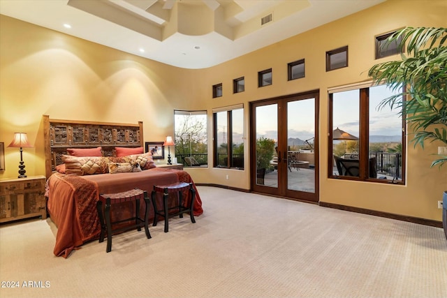 bedroom featuring french doors, access to outside, light colored carpet, ceiling fan, and a high ceiling