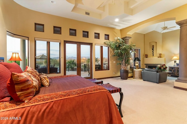 carpeted bedroom with a mountain view, french doors, ceiling fan, access to exterior, and a towering ceiling