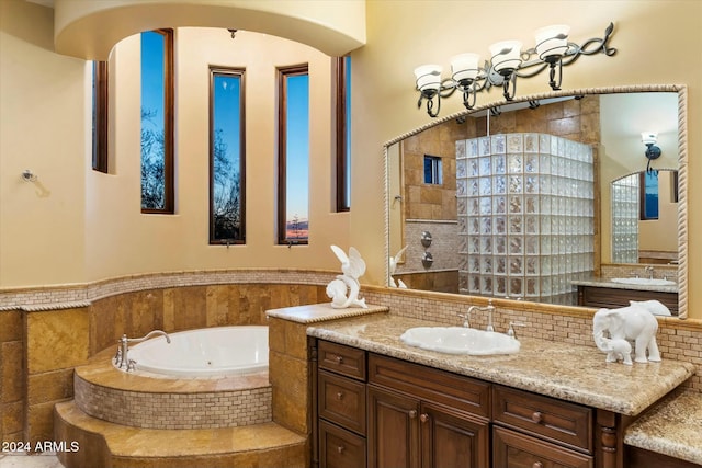 bathroom featuring vanity and tiled bath