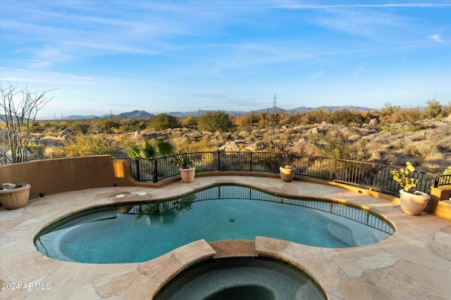 view of swimming pool with an in ground hot tub and a mountain view