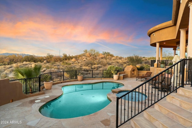 pool at dusk featuring a patio area