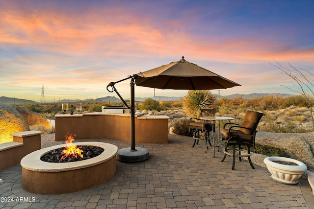 patio terrace at dusk with a mountain view and an outdoor fire pit