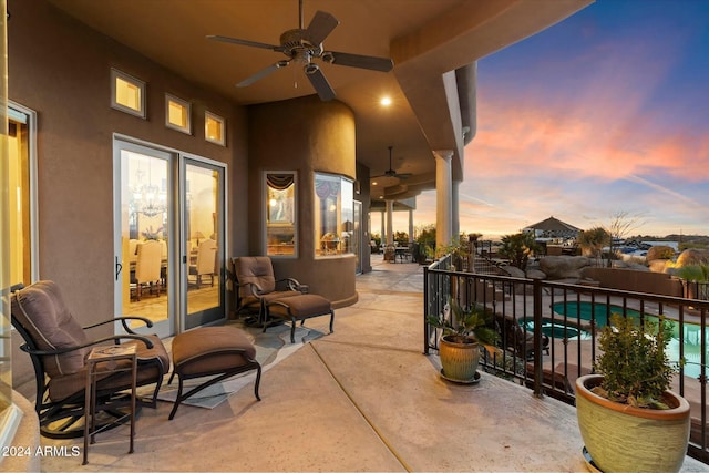 patio terrace at dusk with a fenced in pool and ceiling fan