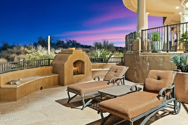 patio terrace at dusk with exterior fireplace