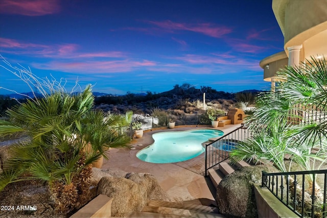 pool at dusk with a patio area