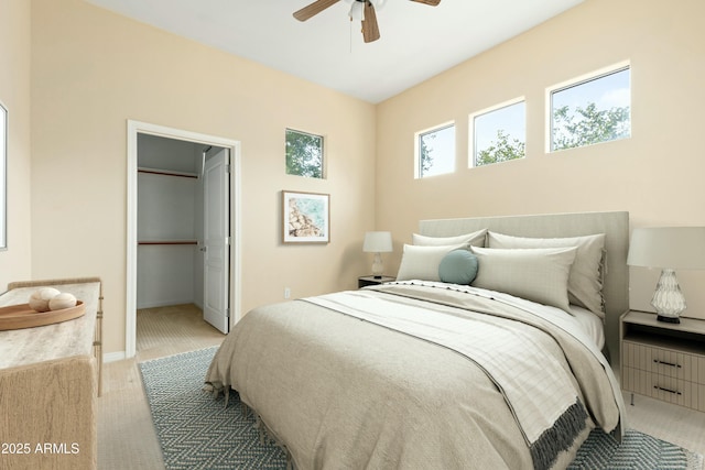 carpeted bedroom featuring ceiling fan, a walk in closet, and a closet