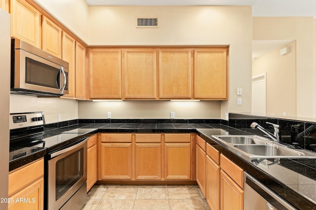 kitchen featuring light brown cabinets, stainless steel appliances, and sink