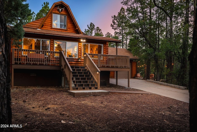 back house at dusk with a wooden deck