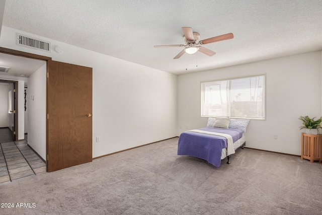 carpeted bedroom featuring a textured ceiling and ceiling fan