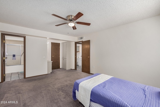 carpeted bedroom with a textured ceiling, connected bathroom, and ceiling fan