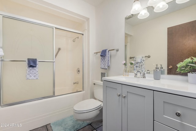 full bathroom with vanity, toilet, tile patterned floors, and bath / shower combo with glass door