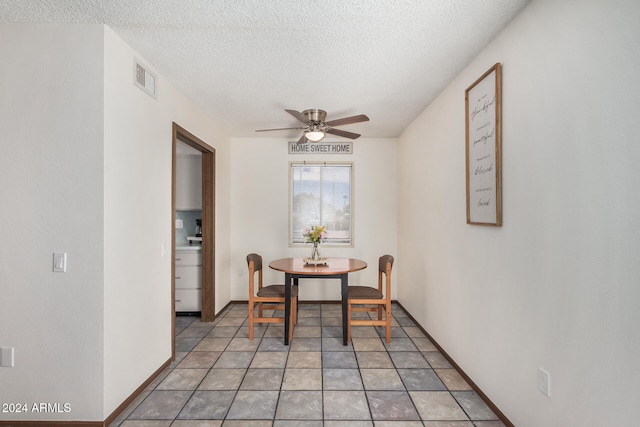 dining room featuring ceiling fan, tile patterned floors, and a textured ceiling