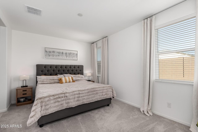 bedroom featuring light carpet and multiple windows