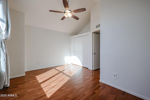 unfurnished bedroom featuring hardwood / wood-style flooring, high vaulted ceiling, a closet, and ceiling fan