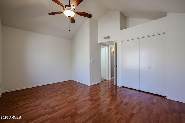 unfurnished bedroom featuring ceiling fan, dark hardwood / wood-style floors, high vaulted ceiling, and a closet