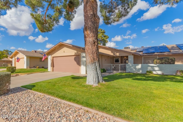 ranch-style house featuring a garage, a front yard, covered porch, and solar panels