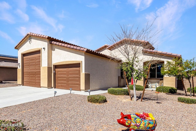 mediterranean / spanish-style house featuring a garage, a tile roof, concrete driveway, and stucco siding