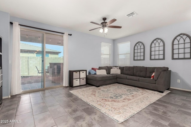 living area with ceiling fan, visible vents, and baseboards