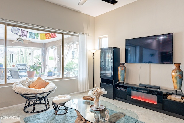 tiled living area featuring baseboards and ceiling fan