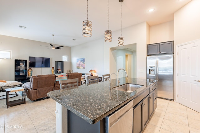 kitchen with visible vents, a sink, dark stone counters, appliances with stainless steel finishes, and ceiling fan