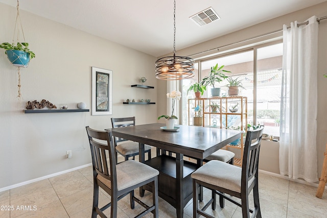 dining area featuring light tile patterned flooring, visible vents, and baseboards