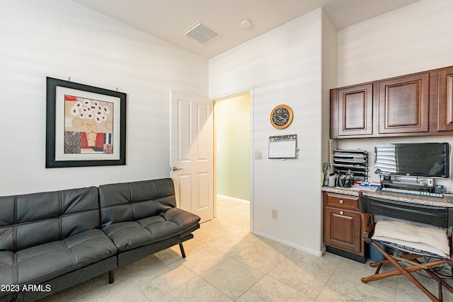 office area featuring visible vents, baseboards, and a towering ceiling