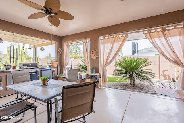 view of patio / terrace with grilling area, outdoor dining space, ceiling fan, and a fenced backyard