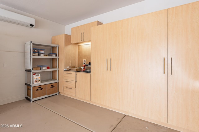 garage featuring a wall mounted air conditioner and baseboards